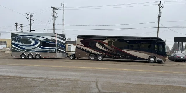Diesel pusher towing a triple-axle stacker trailer with a Trailer Toad