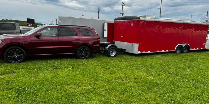 SUV towing a tandem-axle cargo trailer with a Trailer Toad